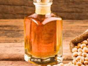 Crude degummed soybean oil in glass bottle with soybeans