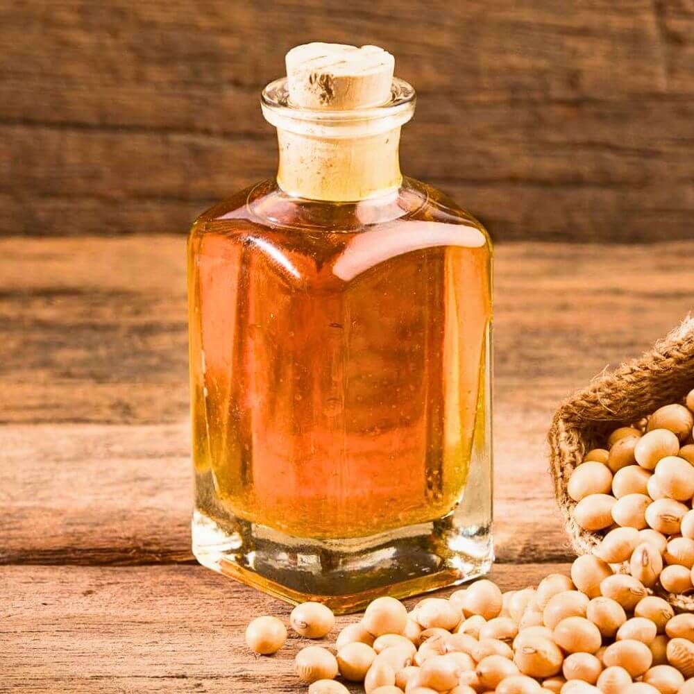 Crude degummed soybean oil in glass bottle with soybeans